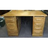 An early 20th century oak twin pedestal desk, each pedestal with four drawers,