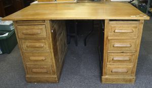 An early 20th century oak twin pedestal desk, each pedestal with four drawers,