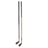 A hickory shaft hand forged iron golf club and a putter,