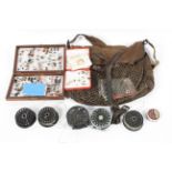 A game keeper's bag with an assortment of fishing flies and fly reels
