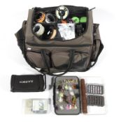 A Daiwa wilderness fishing bag containing a selection of fishing reals, flys and related items,