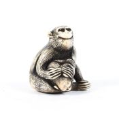 A Meiji period ivory netsuke of seated monkey holding a baby monkey searching for the fruit hidden