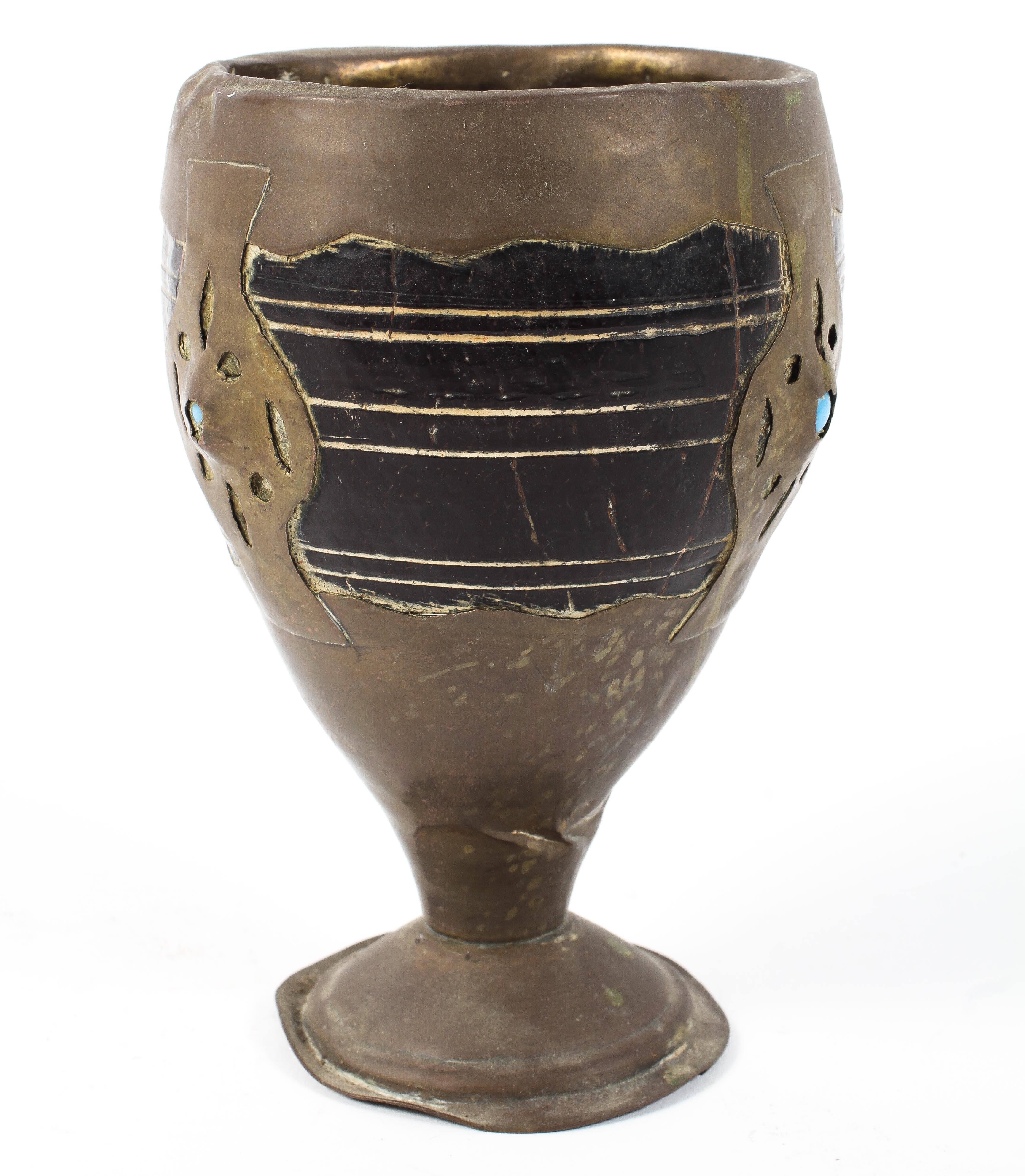 A Middle Eastern Coconut cup set within a brass holder and pedestal decorated with turquoise beads