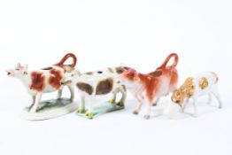 Two 19th century Staffordshire pottery cow creamers and one later together with a model of a calf