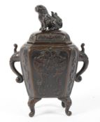 A Chinese Qing dynasty bronze lidded incense burner decorated in relief with twin phoenix and