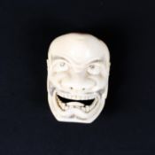 A late 19th/early 20th century mask netsuke of a demon,