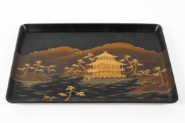 A large Japanese dark brown lacquer tray decorated in gold makie with a pavillion in a river