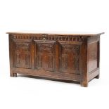 An 18th century oak coffer, with three carved panels and carved frieze,