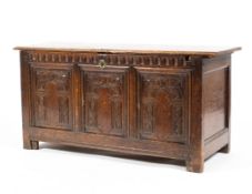 An 18th century oak coffer, with three carved panels and carved frieze,