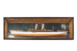 A half wooden carved model of a twin funnel steam ship EMPRESS OF INDIA mounted on glass and f&g