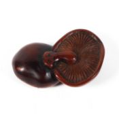 A 19th century wood netsuke of softly carved two mushrooms lying cap on cap, length 6.