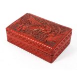 A Qing dynasty Chinese red lacquer lidded box carved to the lid with scholars and attendants in a