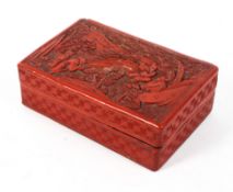 A Qing dynasty Chinese red lacquer lidded box carved to the lid with scholars and attendants in a