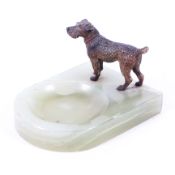 A late 19th/early 20th century onyx ashtray surmounted with a cold painted bronze model of a dog,