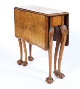 An early 20th century walnut drop leaf side table raised on carved cabriole supports to ball and