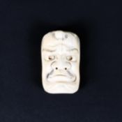 A late 19th/early 20th century ivory mask netsuke of a man,