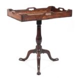 A Georgian mahogany tilt top butlers tray/table raised on a turned baluster column to a tripod