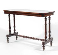A Victorian rosewood side table raised on turned double columns and turned stretchers to short ball