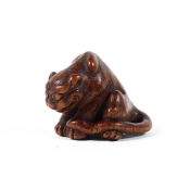 A 19th century wood netsuke of a tiger in the style of Masanao,