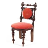 A Victorian mahogany child's upholstered chair with turned carved frame and overstuffed seat raised