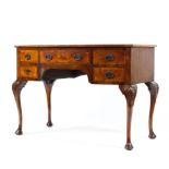 A 20th century bow fronted walnut desk (sun bleached top) with central drawer flanked by four short