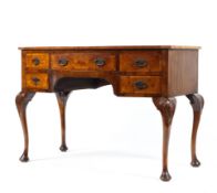 A 20th century bow fronted walnut desk (sun bleached top) with central drawer flanked by four short