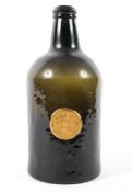 An early 19th century green glass mallet shaped wine bottle, with applied label inscribed 'T.