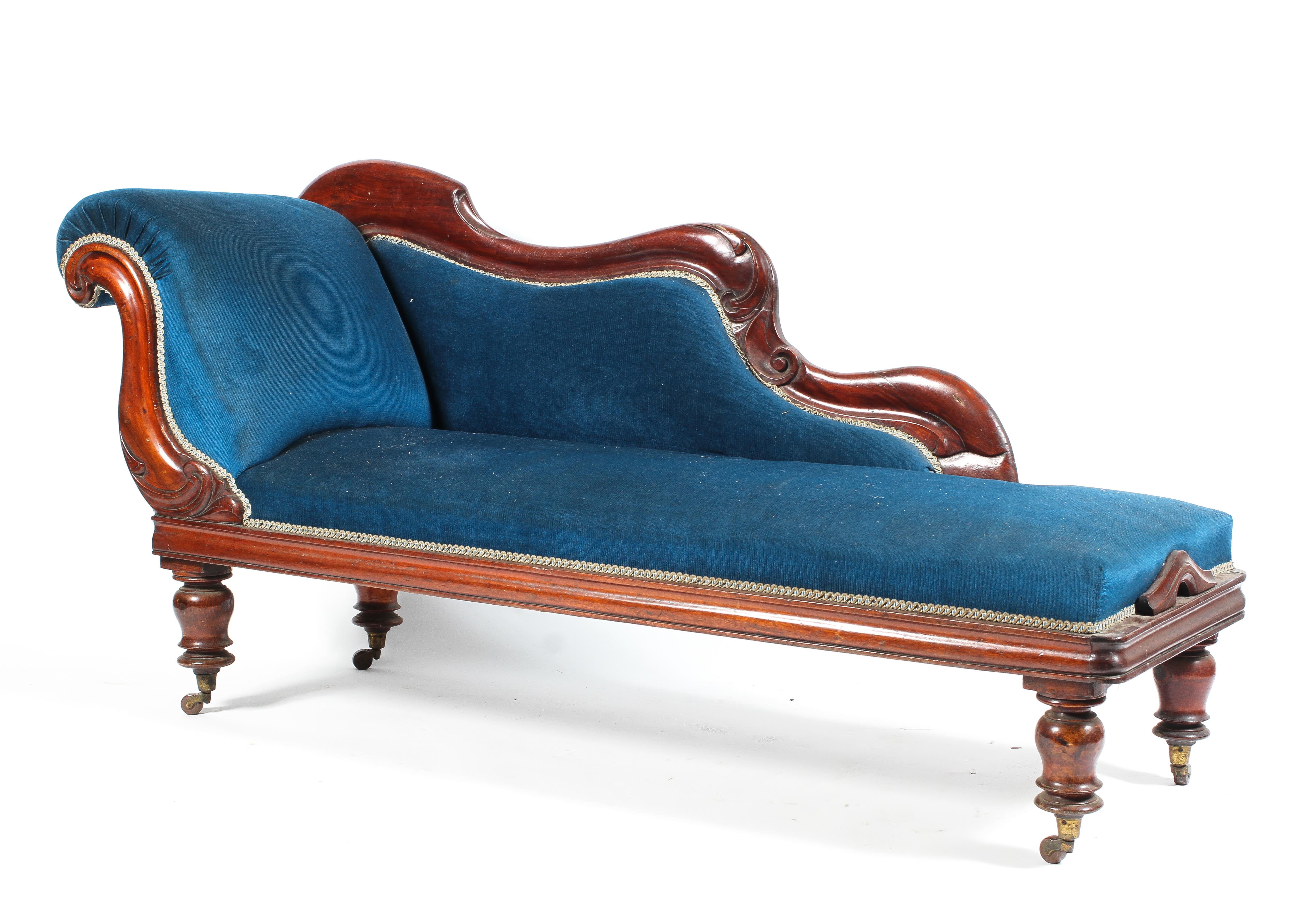 A Victorian mahogany framed chaise lounge re-upholstered with arched side panel raised on turned