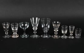 A collection of antique drinking glasses, including firing glasses, wine and liquer glasses,