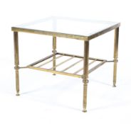 An early 20th century brass glass topped side table with slatted under tier raised on reeded