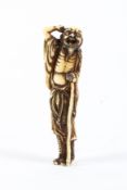 An 18th/19th century ivory netsuke of a standing sennin, his right arm raised to his head,