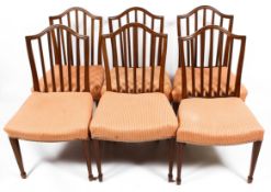 A set of six Edwardian mahogany arch backed dining chairs with square spindle backs and