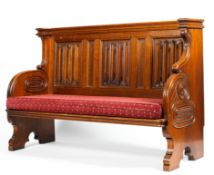 An early 20th century church pew with linenfold panel back rest and carved side,