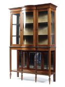 An Edwardian inlaid mahogany serpentine fronted glazed display cabinet with mirror backed under