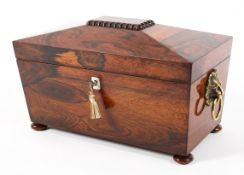 A 19th Century rosewood sarcophagus shaped tea caddy with lion ring handles.