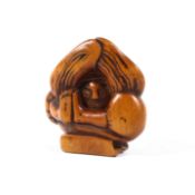 A Meiji dynasty wood netsuke of a dancer crouching with his head placed between his arms