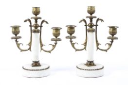 A pair of short gilded three branch candelabras raised on an alabastar corinthian column base,