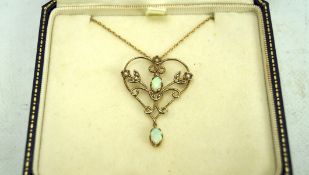 An Edwardian 9ct gold and opal pendant, on a 9ct gold chain,