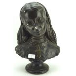 A plaster bust of a yound lady, painted black and on a circular plinth,