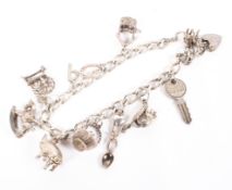 A silver curb link charm bracelet, with an assortment of eight charms,