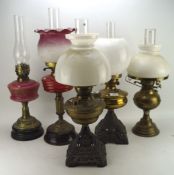 A collection of five late 19th/early 20th century oil lamps, one with painted glass reservoir,