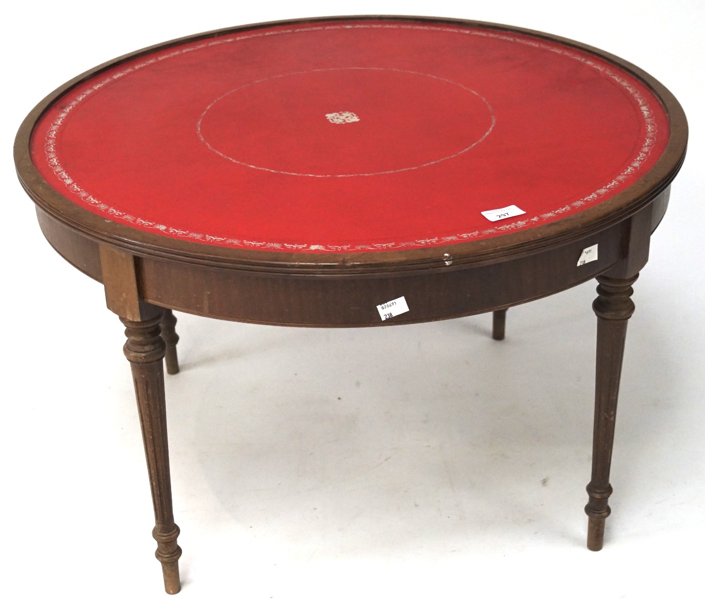 An oak coffee table, of circular form, with tooled leather top,