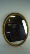 A vintage 1970s gilt framed wall mirror, of oval form,