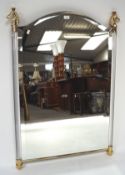 A contemporary wall mirror with perspex columns and horse head finials,