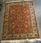 A 20th century Israeli floor rug, with floral motifs throughout on a red ground,