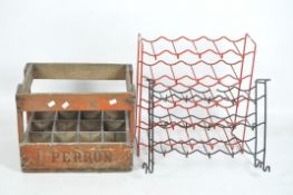 A vintage wooden bottle crate and two metal wine racks, the crate branded Perron, dated 1964,