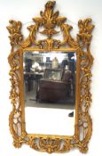 A large modern gilt wood wall mirror with pierced foliate frame,