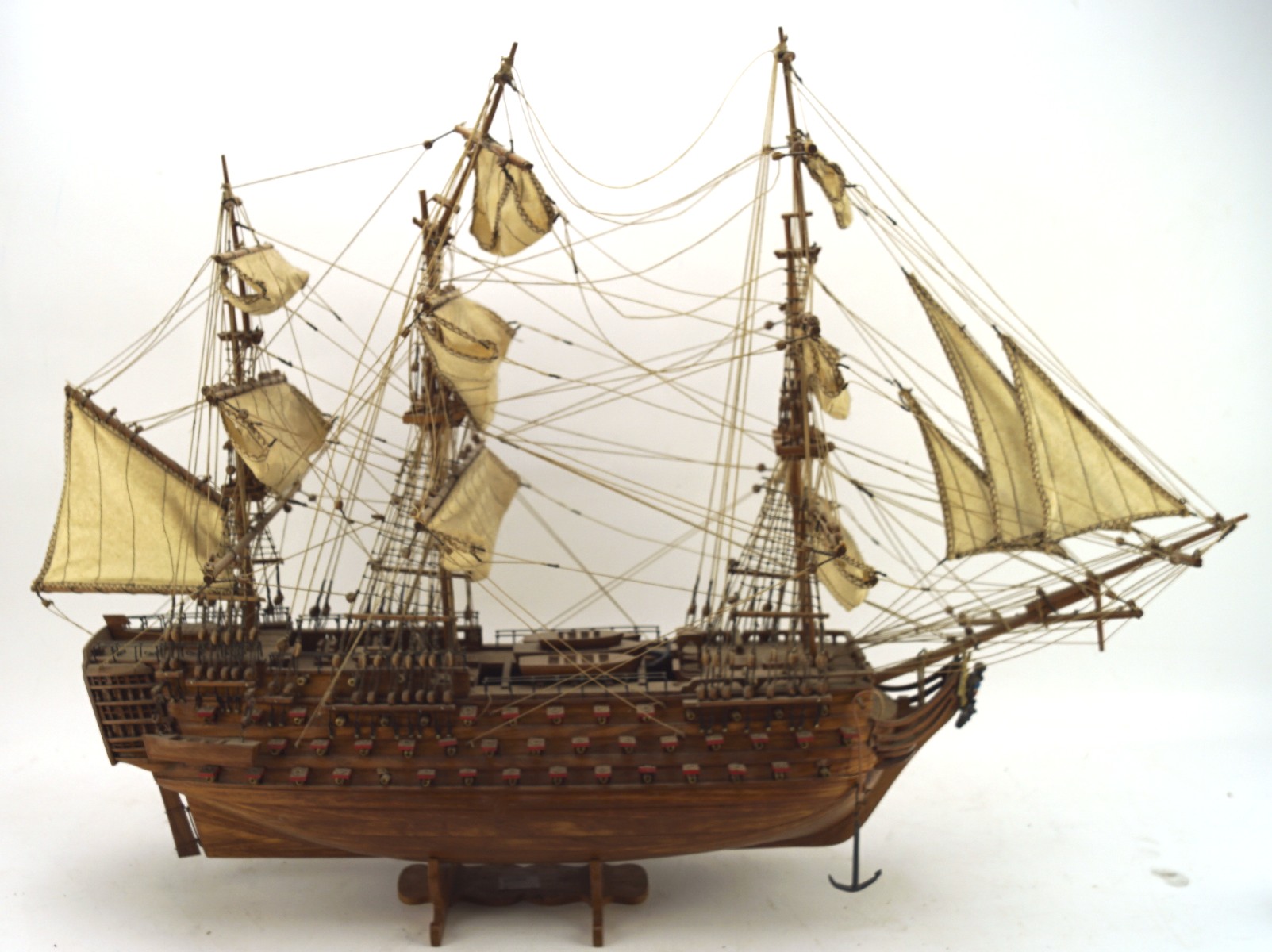 A vintage scratch built wooden model of a three masted boat, on stand,