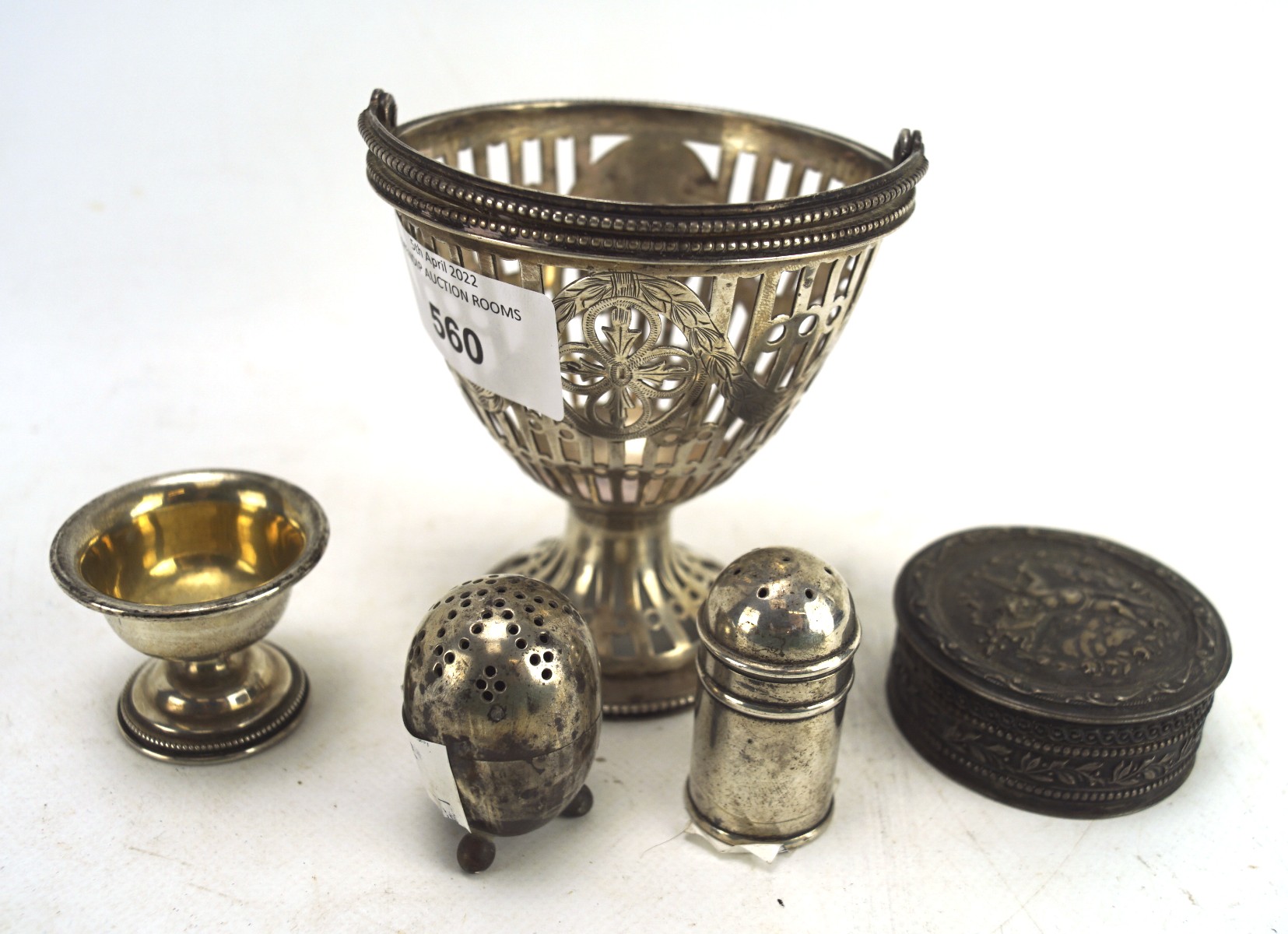 A collection of silver and white metal, including a pierced dish with a handle to the top, and more