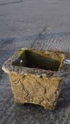 A reconstituted stone planter, of square form on plinth,